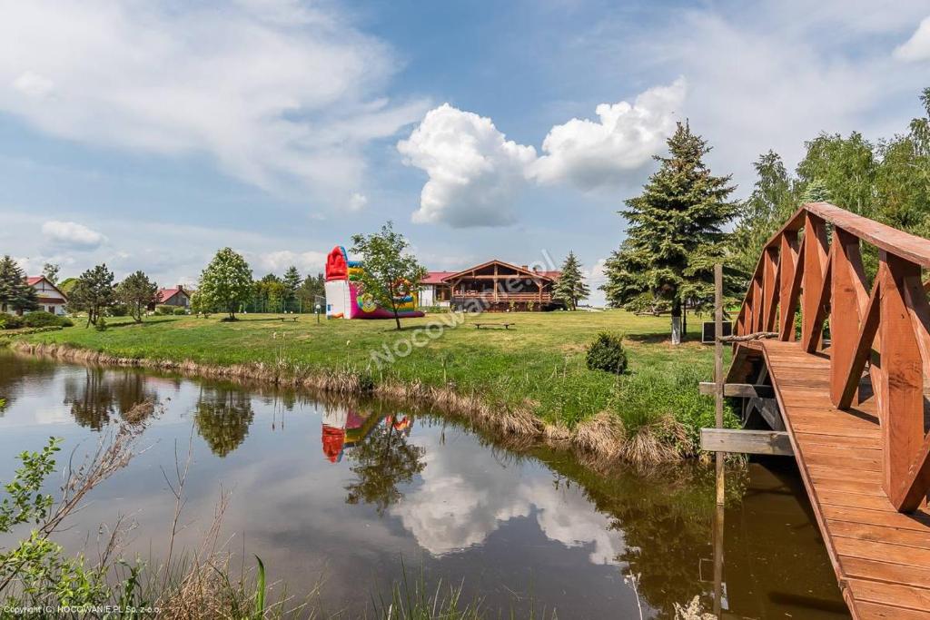 een brug over een rivier met een vuurtoren op de achtergrond bij Mimoza Gospodarstwo Agroturystyczne in Bartoszyce