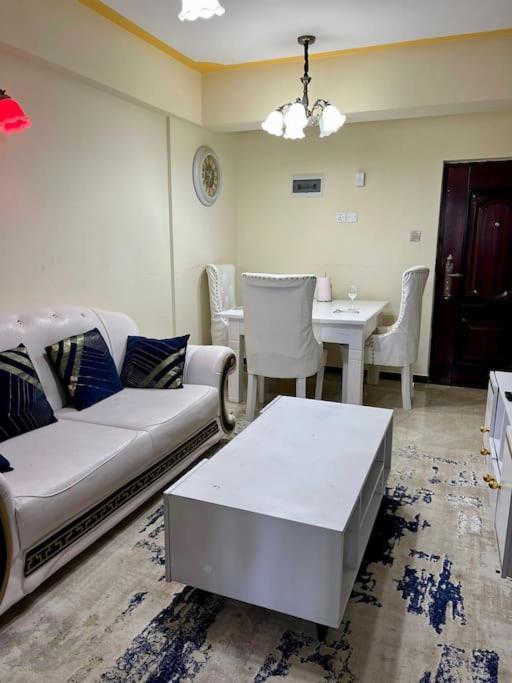 - un salon avec un canapé et une table dans l'établissement Forest's Simplistic Home with a dedicated study, à Nairobi