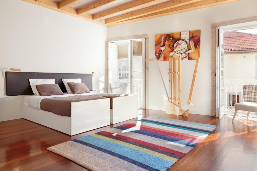 um quarto com uma cama e um tapete colorido em ExtendALL no Porto