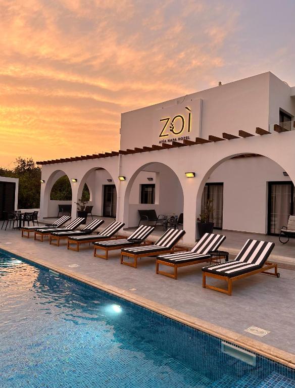 a resort with lounge chairs and a swimming pool at Zoi Ayia Napa in Ayia Napa