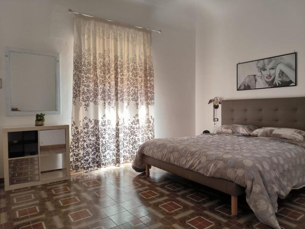 a bedroom with a bed and a large window at Casa obelix - kasbah in Mazara del Vallo