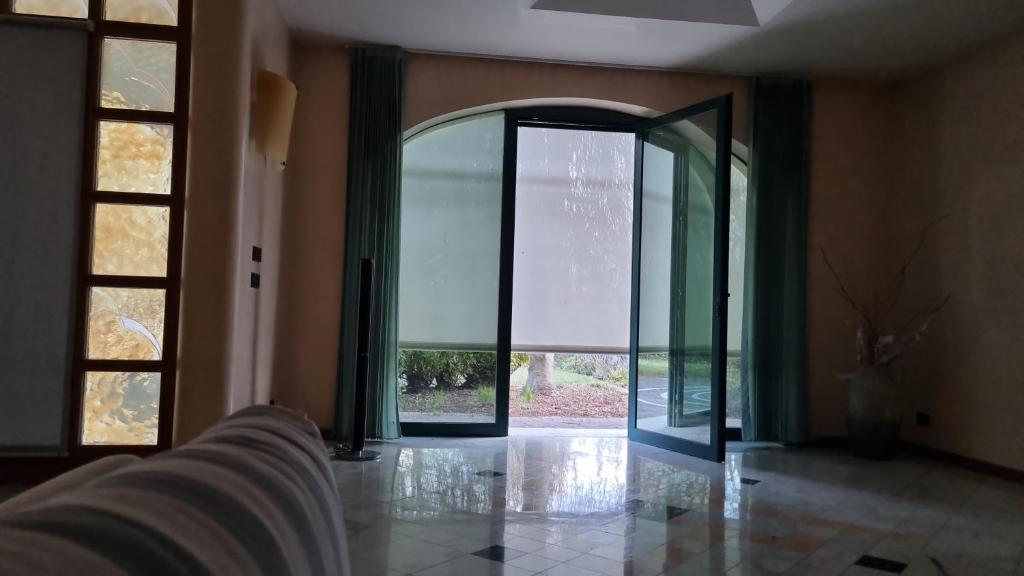 une porte en verre ouverte dans une pièce avec une arche dans l'établissement Villa Contea, à Scorzè
