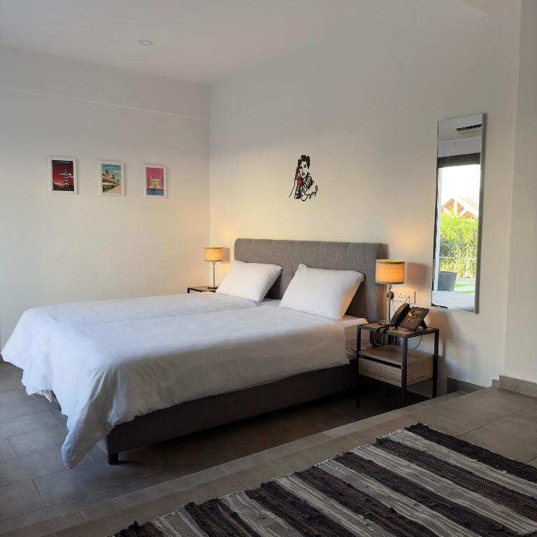 a bedroom with a bed with two lamps and a window at Zoi Ayia Napa in Ayia Napa