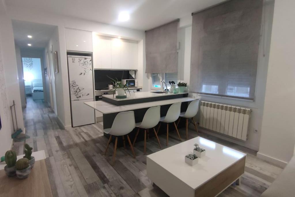een keuken met een bar met stoelen en een tafel bij Apartamento Turquesa in Zaragoza