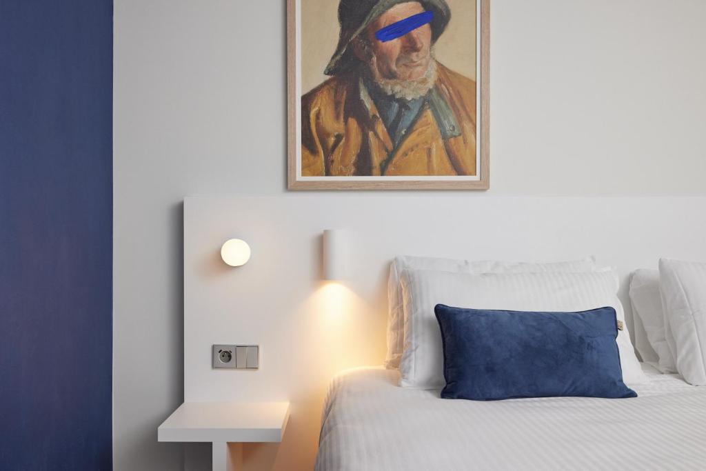 een slaapkamer met een bed met een schilderij aan de muur bij C-Hotels Burlington in Oostende