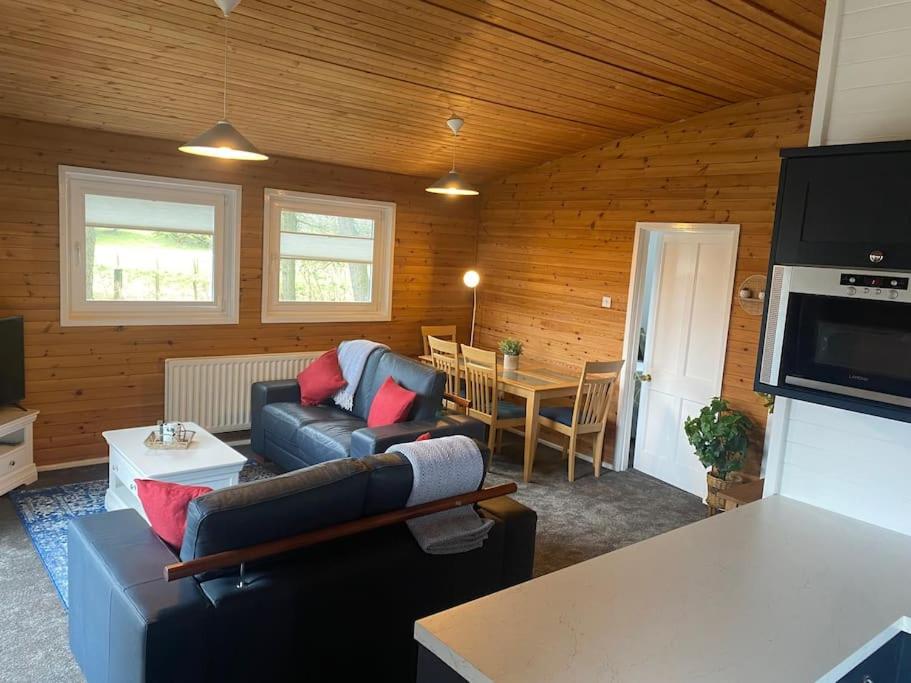 a living room with a couch and a table at Hideaway Lodge in Carnforth