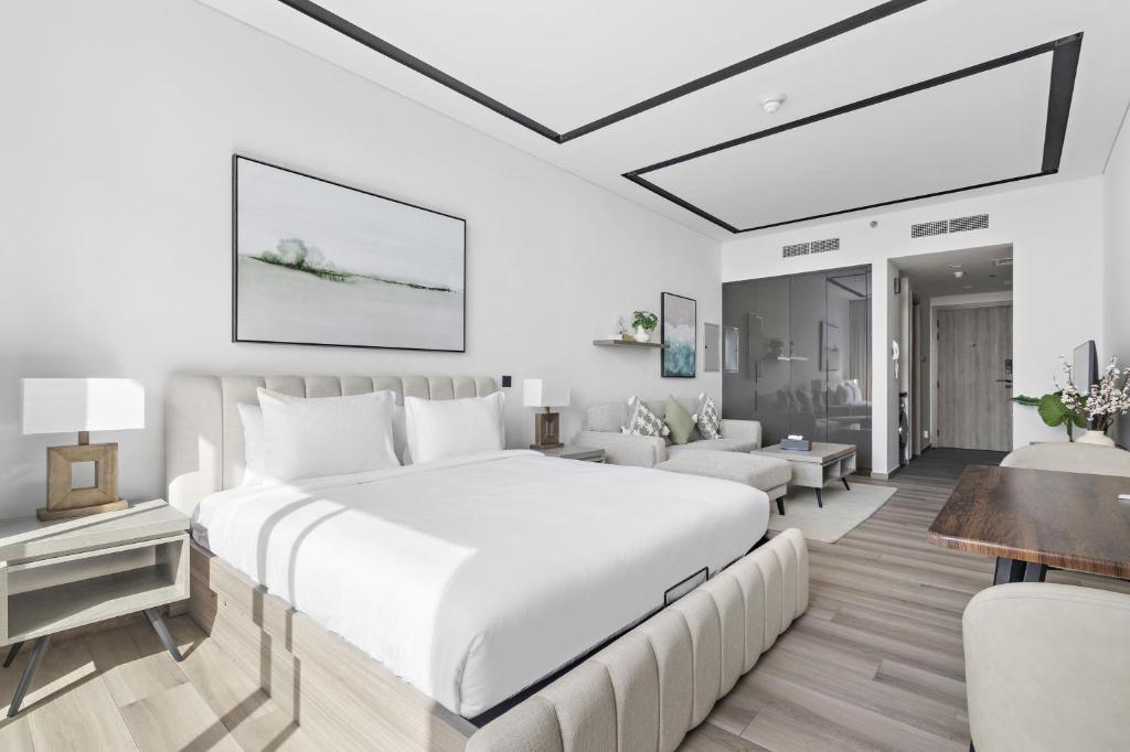 ein Schlafzimmer mit einem großen Bett und ein Wohnzimmer in der Unterkunft A Living Luxury Studio Nicholas Residence JVC in Dubai