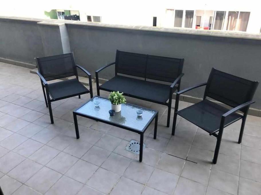 3 sillas y una mesa de centro en un patio en Camarote 303, en Barbate