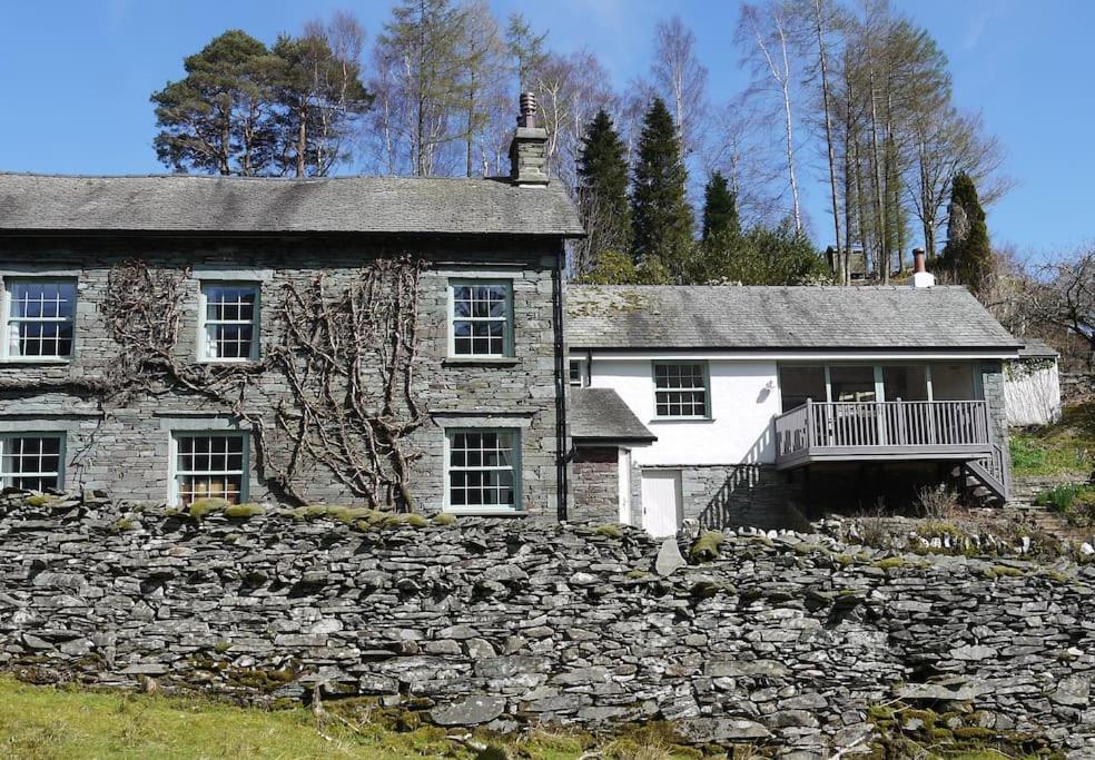 an old stone house with a stone wall at Langdale Cottage - 5 bedrooms and 5 bathrooms in Chapel Stile