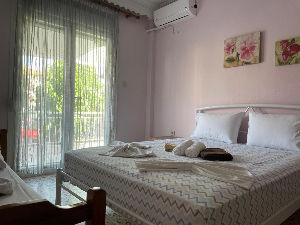 a bedroom with a white bed with towels on it at Villa Maria Petru in Ierissos