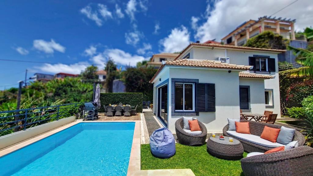 eine Villa mit einem Pool und einem Haus in der Unterkunft Villa Liana by LovelyStay in Ponta do Sol