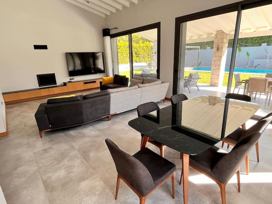 a living room with a couch and a table and chairs at Sakin ve huzurlu bir tatil için… in Çeşme