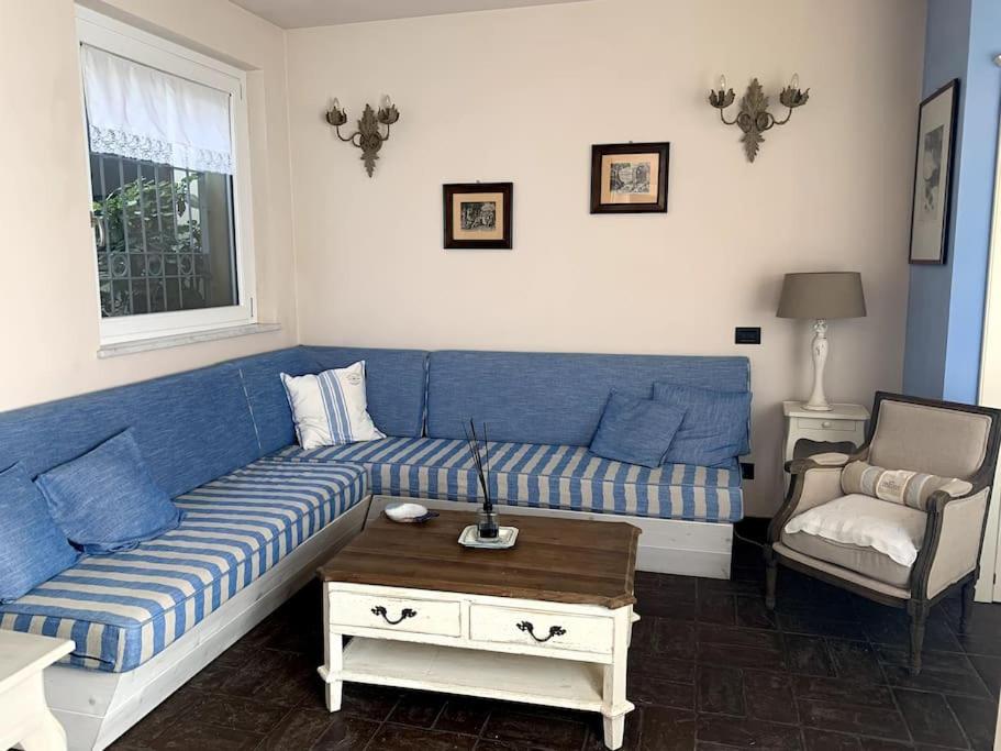 uma sala de estar com um sofá azul e uma cadeira em Casa Gelsomino em Forte dei Marmi