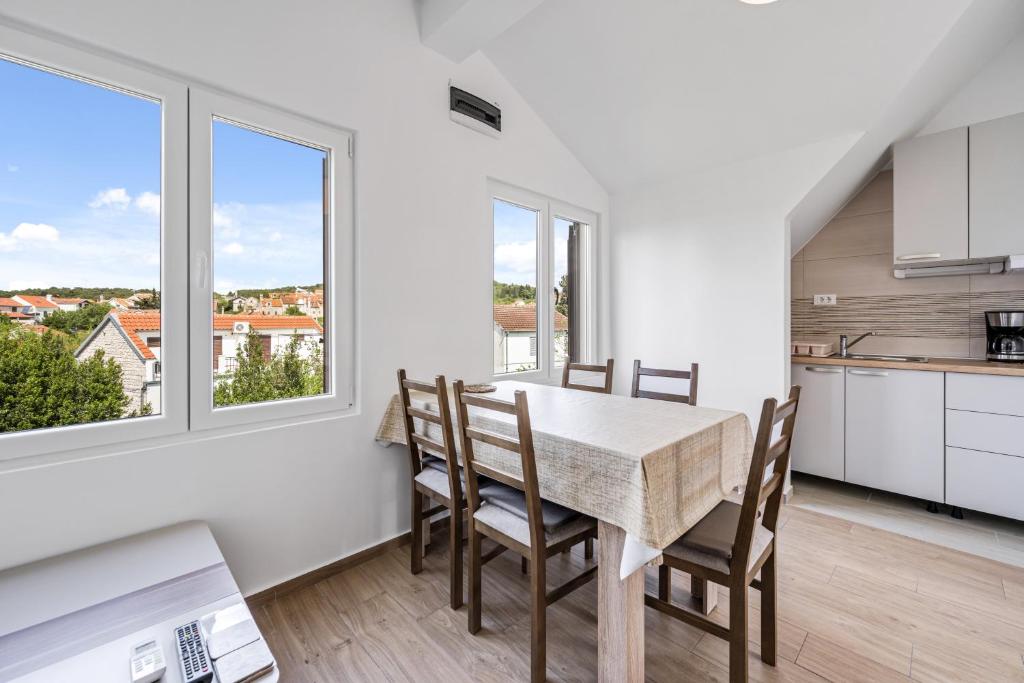 een keuken en eetkamer met een tafel en stoelen bij Apartments Zlarin in Zlarin
