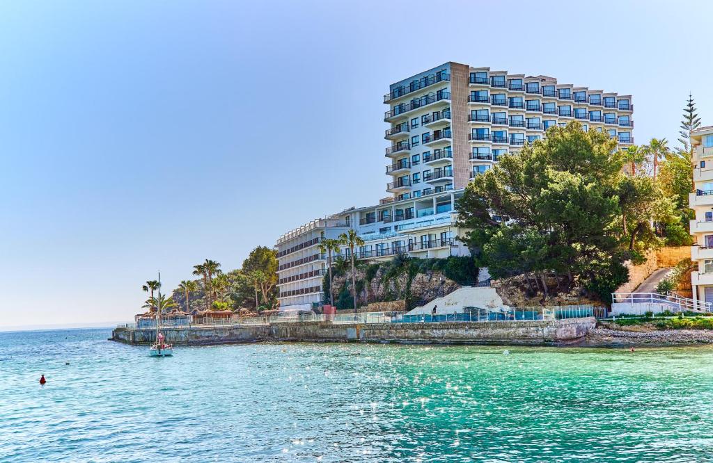 un gran edificio a orillas de un cuerpo de agua en Leonardo Royal Hotel Mallorca, en Palmanova