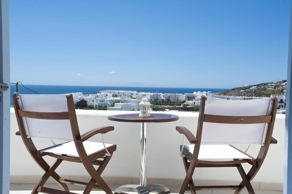 Duas cadeiras e uma mesa numa varanda com vista em Villa Nireas em Platis Gialos, Mykonos