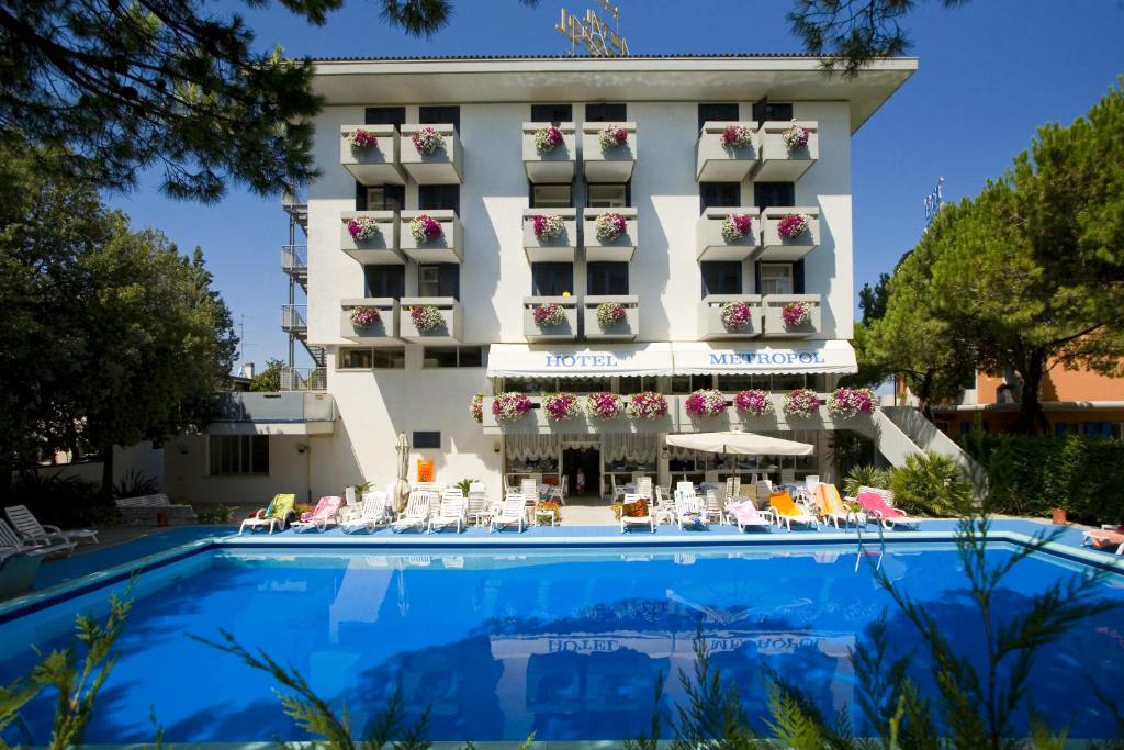 a hotel with a swimming pool in front of a building at Hotel Metropol in Caorle