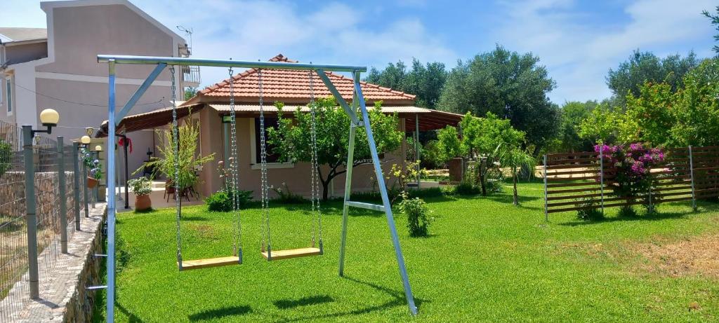 a yard with a swing set in front of a house at VASIANA Country House in Razáta