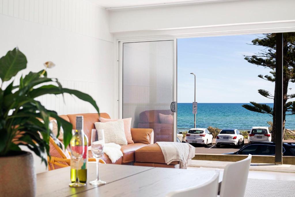 a living room with a couch and a view of the ocean at Luxury Beachfront Retreat on Henley Beach Esplanade in Henley Beach South