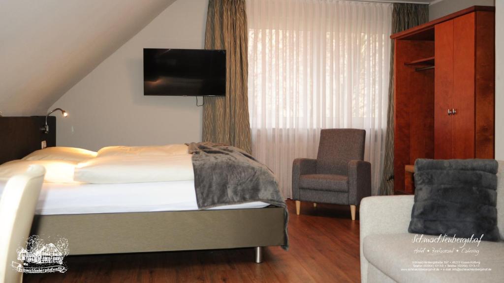 Pokój hotelowy z łóżkiem i krzesłem w obiekcie Hotel-Restaurant Schmachtenbergshof w Essen