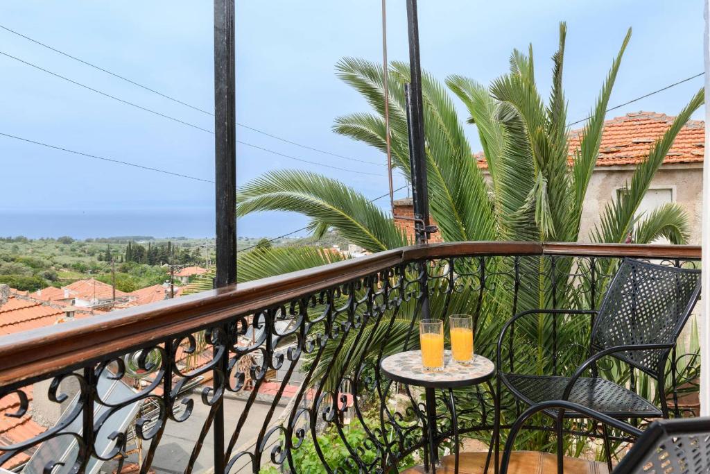 two glasses of orange juice on a table on a balcony at Heaven's house in Kallirákhi
