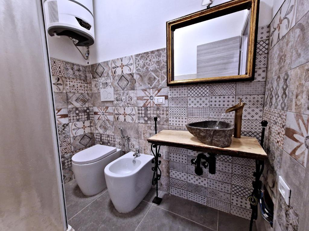 La salle de bains est pourvue d'un lavabo, de toilettes et d'un miroir. dans l'établissement La Ca' Pezzana Affittaly Apartments, à Bologne