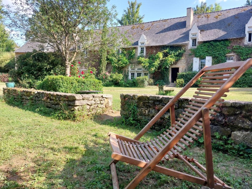 a wooden bench sitting in front of a house at Maison d'hôtes de La Roche Tabary 