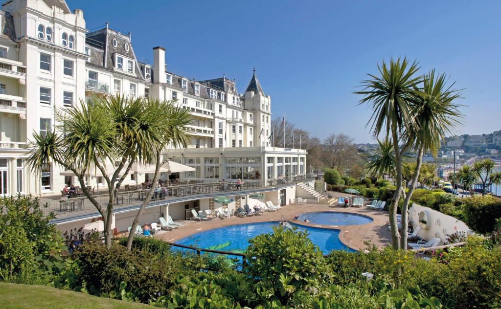 een uitzicht op een hotel met een zwembad en palmbomen bij The Grand Hotel in Torquay