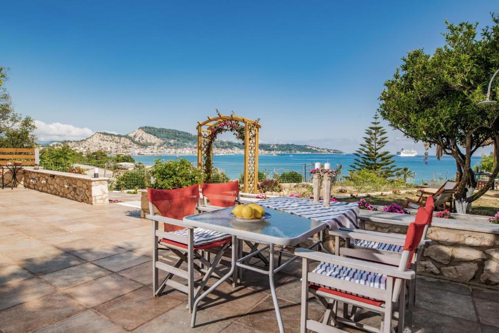una mesa y sillas en un patio con vistas al océano en Orientem Villa en Argasi