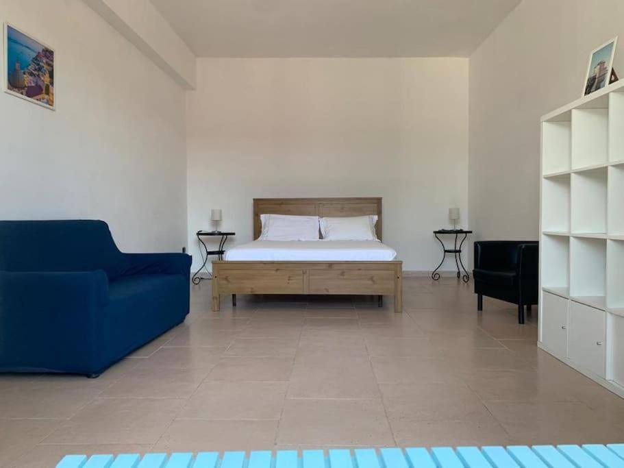um quarto com uma cama e um sofá azul em Casa Stella del Vesuvio em Portici