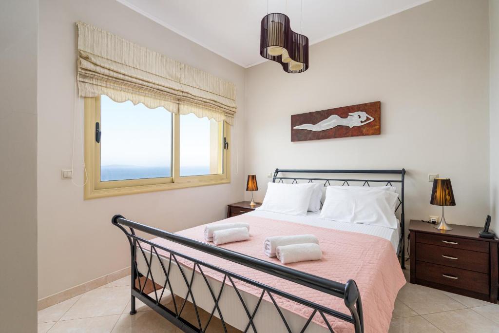 a bedroom with a bed and a window at Artemisia Sunset View in Sitia