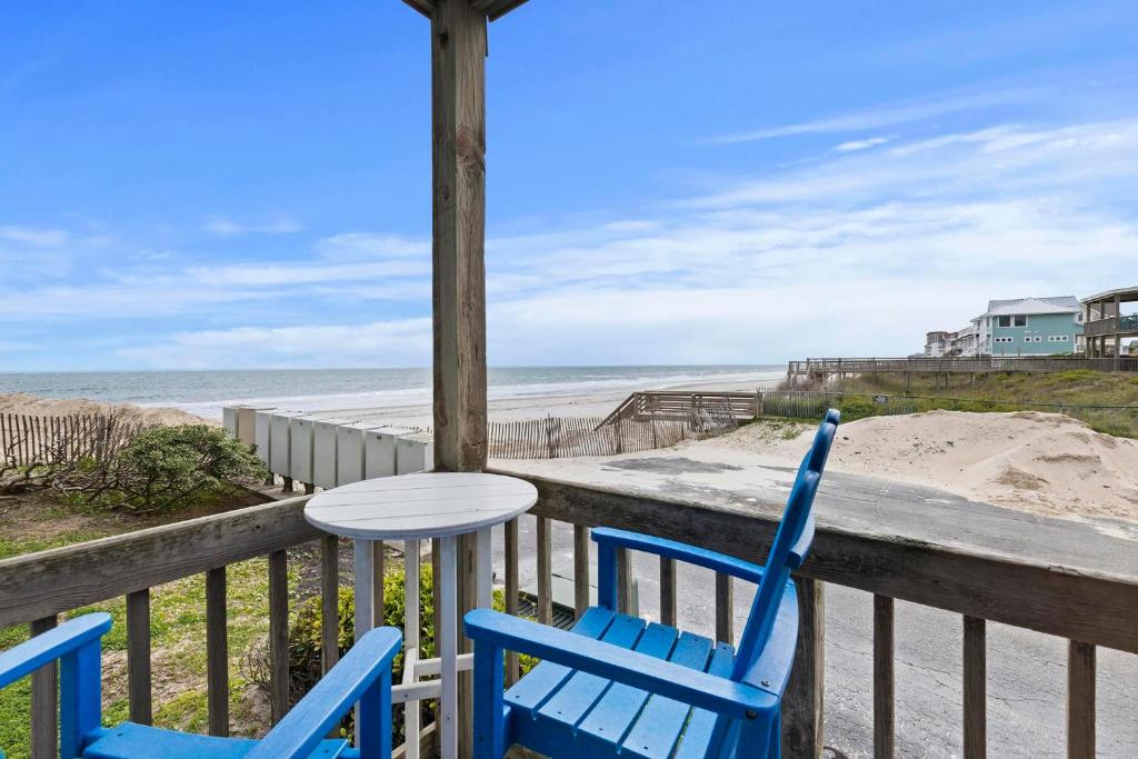 een tafel en twee stoelen op een veranda met het strand bij Out To Sea - Oceanfront 2 Bedroom, 2 Bath Condo in North Topsail Beach