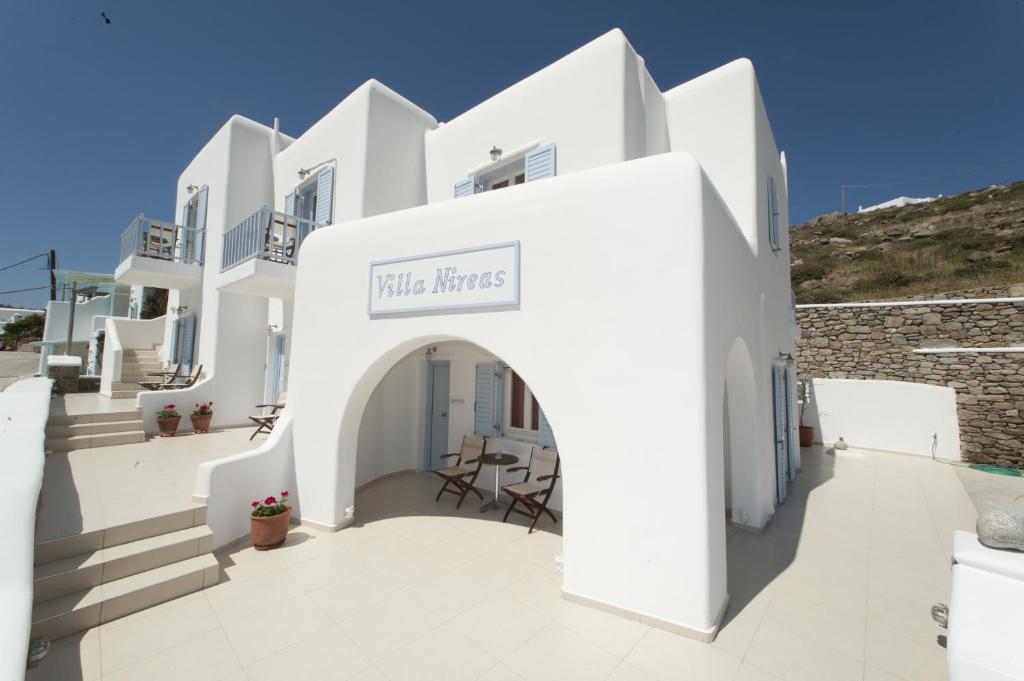 a white building with a sign that reads little houses at Villa Nireas in Platis Gialos