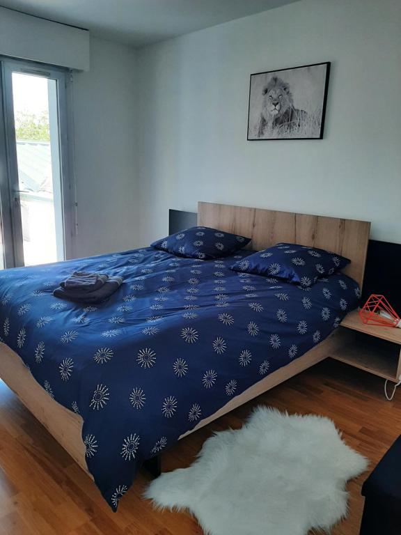 1 dormitorio con 1 cama con edredón azul en Le relais des trois châteaux en Flixecourt