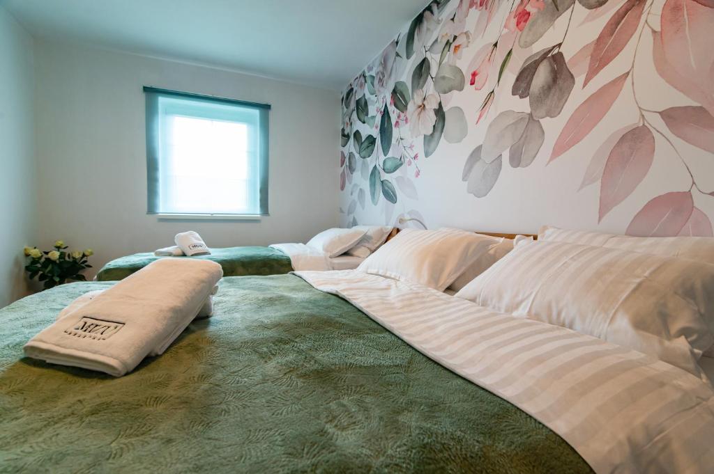 a large bed with pillows on it in a room at MIZU APARTMA VAS LIPA OLIMJE in Podčetrtek