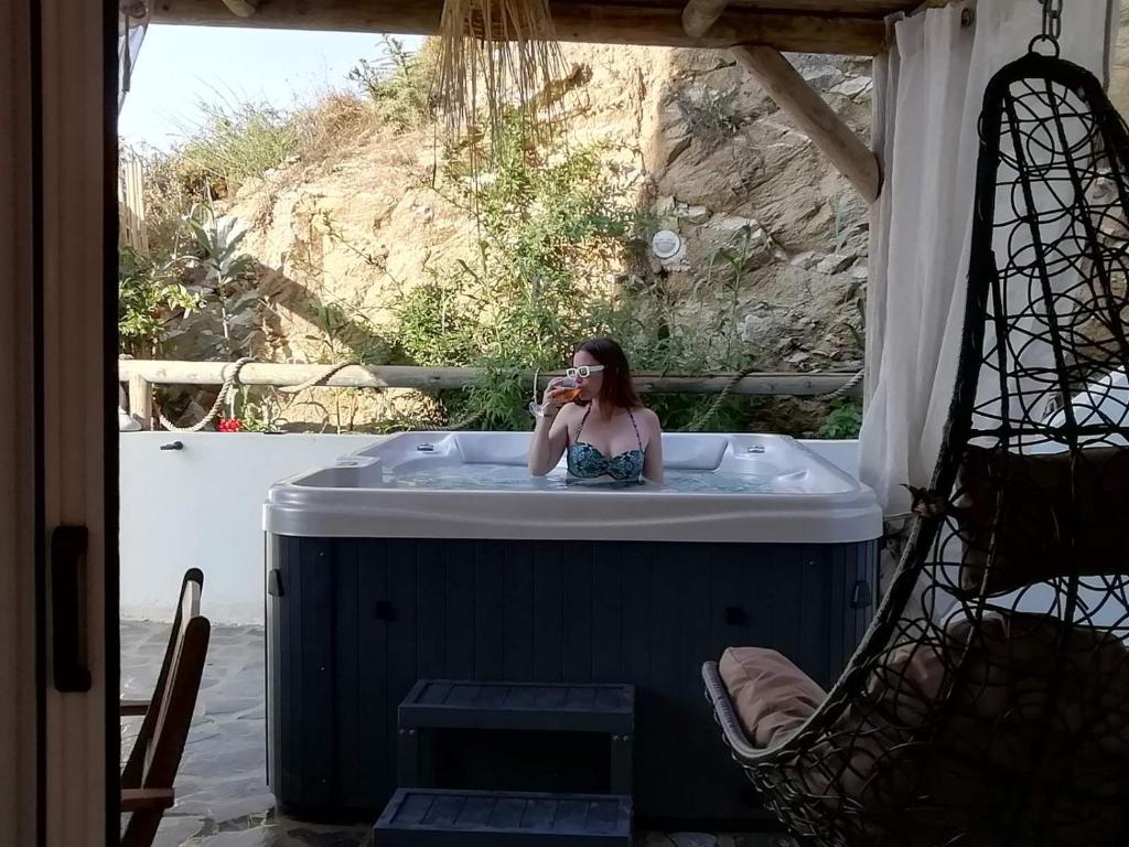 a woman taking a picture in a bath tub at Janakos Luxury Apartment in Glinado Naxos
