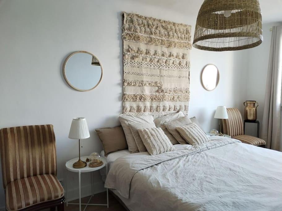 1 dormitorio con 1 cama, 2 sillas y espejo en Massilia Calling love Appartement de standing 8 personnes Marseille proche métro parking facile en Marsella
