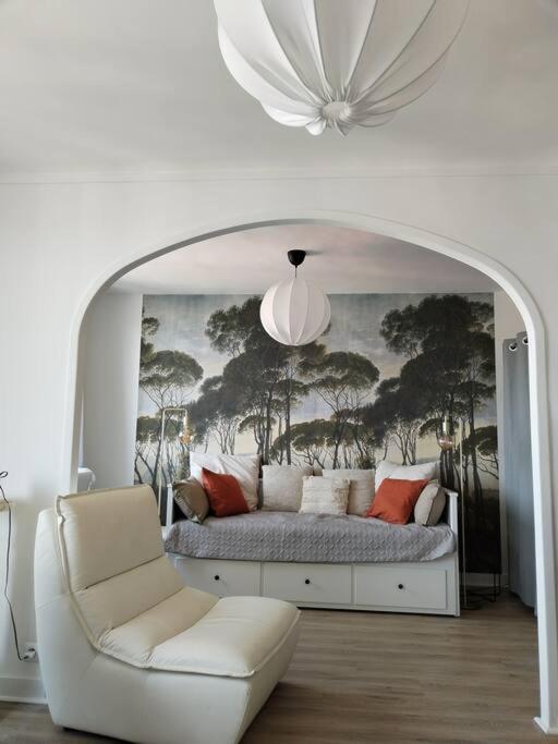 a bedroom with a bed and a chair and a chandelier at Massilia Calling love Appartement de standing 8 personnes Marseille proche métro parking facile in Marseille