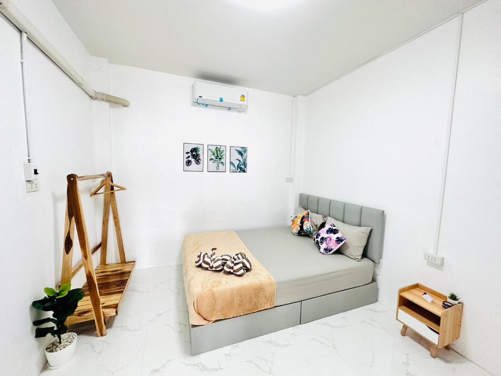 een slaapkamer met een bed in een witte kamer bij Avita Pool Villa in Sichon