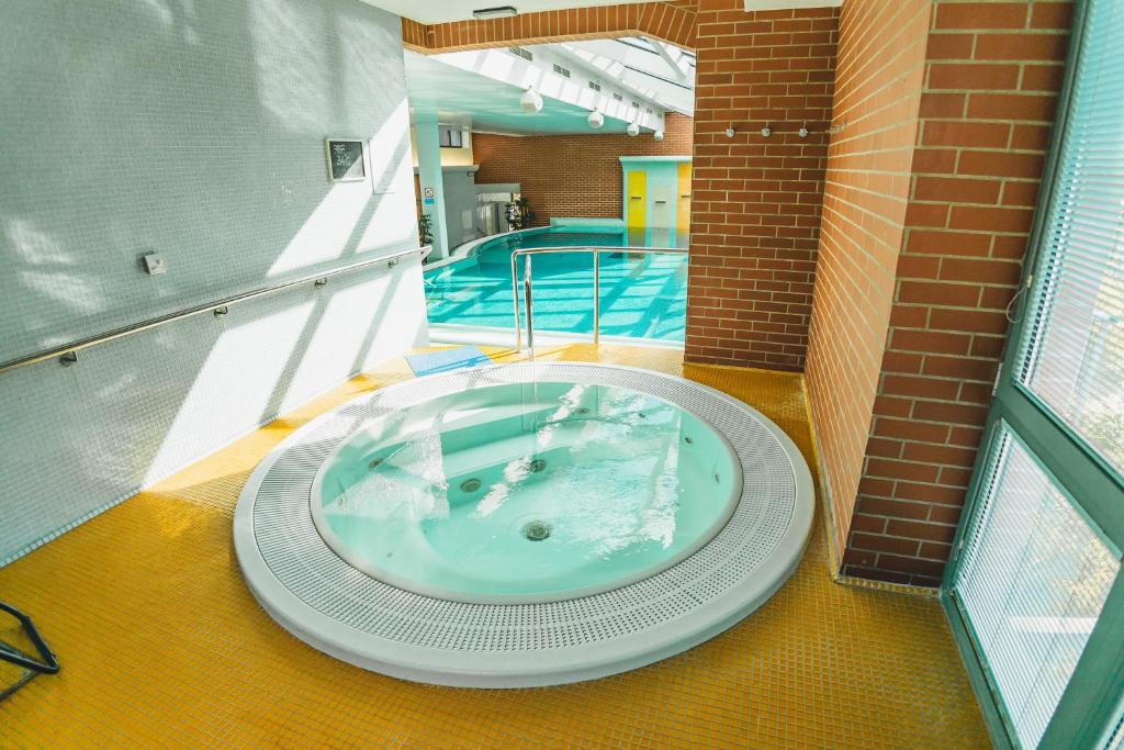 a large tub in a building with a swimming pool at St. Joseph Royal Regent in Karlovy Vary