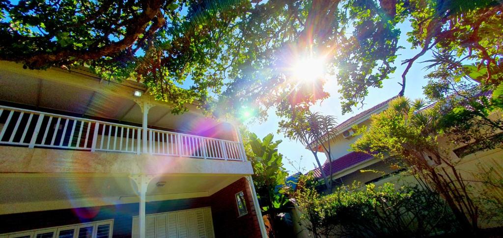 a building with the sun shining through a tree at Beach Haven - Sleeps 10 - Tastefully Furnished Holiday Home! in Margate