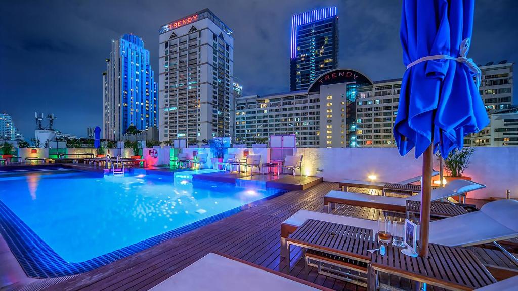una piscina con vistas al perfil urbano por la noche en Night Hotel Bangkok - Sukhumvit 15, en Bangkok