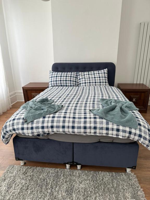 una cama con una manta a cuadros encima en Private room 2 en Londres