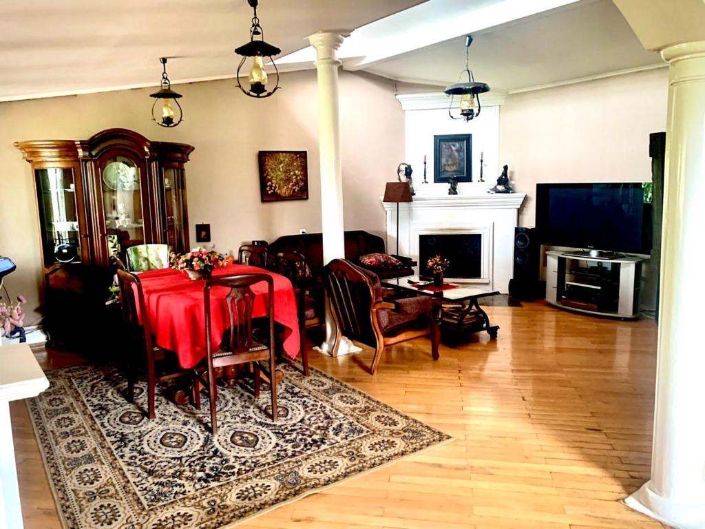 sala de estar con mesa y chimenea en Polonia Tbilisi House, en Tiflis
