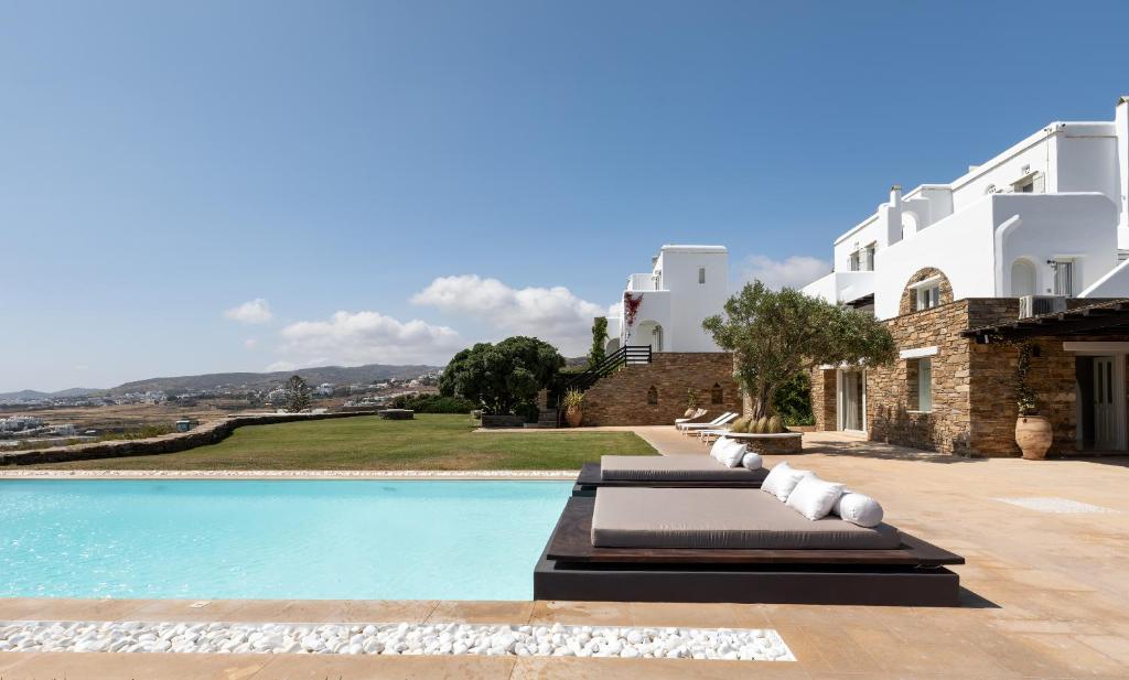 a villa with a swimming pool and a house at Villa Ainar in Tinos Town