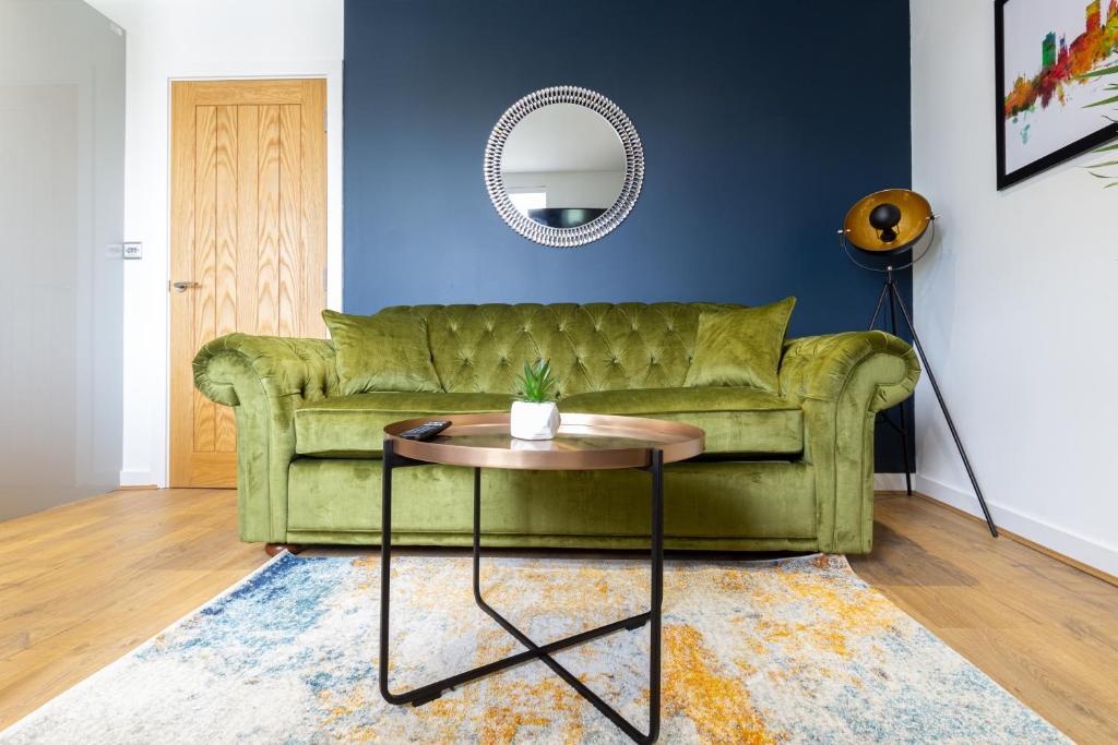 a living room with a green couch and a table at Albion at the Level - 2 BD Flat in Brighton & Hove