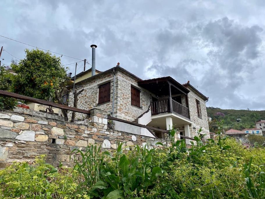 a stone house with a balcony on a stone wall at Katerina's Guest House in Promírion