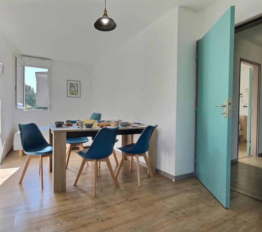 een eetkamer met een tafel en blauwe stoelen bij Tout Inclus - Plein Centre - Netflix - Moontown in Lunéville