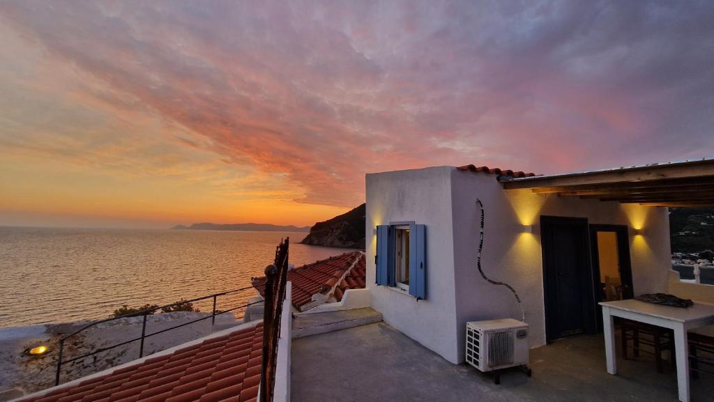 a house with a view of the ocean at sunset at Peppermint Bay in Skopelos Town