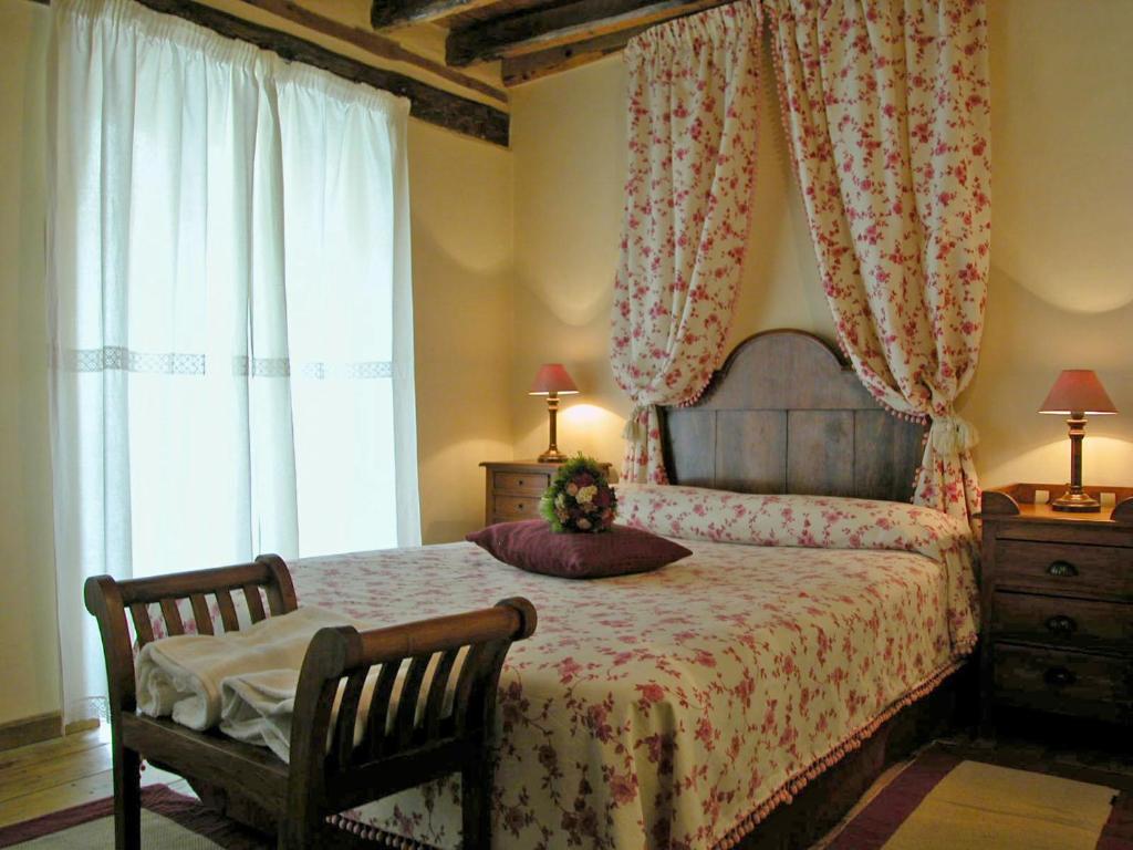 1 dormitorio con 1 cama, 1 silla y 1 ventana en Casa rural Álamo - Valle de El Paular, en Rascafría